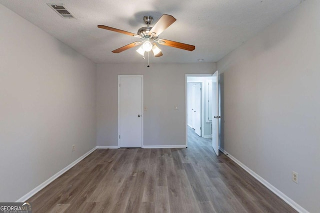 unfurnished bedroom featuring ceiling fan, hardwood / wood-style flooring, and a textured ceiling