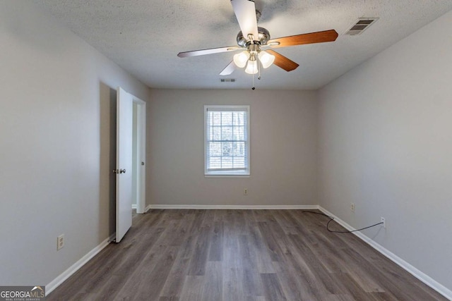 spare room with ceiling fan, dark hardwood / wood-style flooring, and a textured ceiling