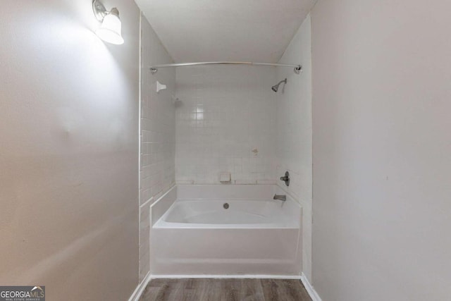 bathroom featuring tiled shower / bath combo and wood-type flooring