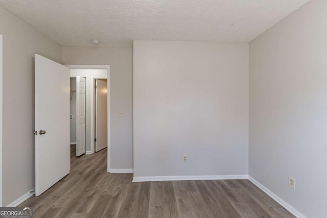 empty room featuring light hardwood / wood-style flooring and a textured ceiling
