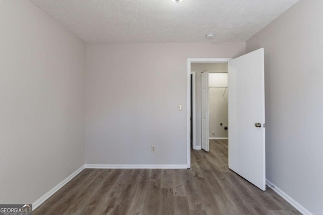 spare room with hardwood / wood-style floors and a textured ceiling