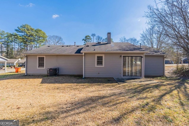 rear view of house featuring a yard and central AC unit