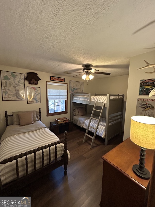 bedroom featuring ceiling fan, dark hardwood / wood-style flooring, and a textured ceiling