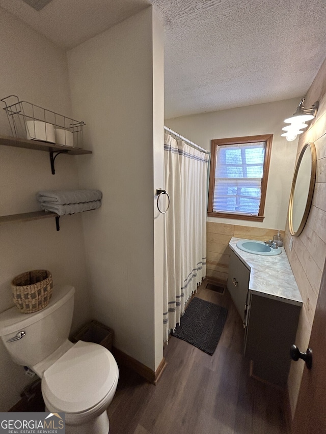 bathroom with hardwood / wood-style floors, vanity, toilet, a textured ceiling, and a shower with shower curtain