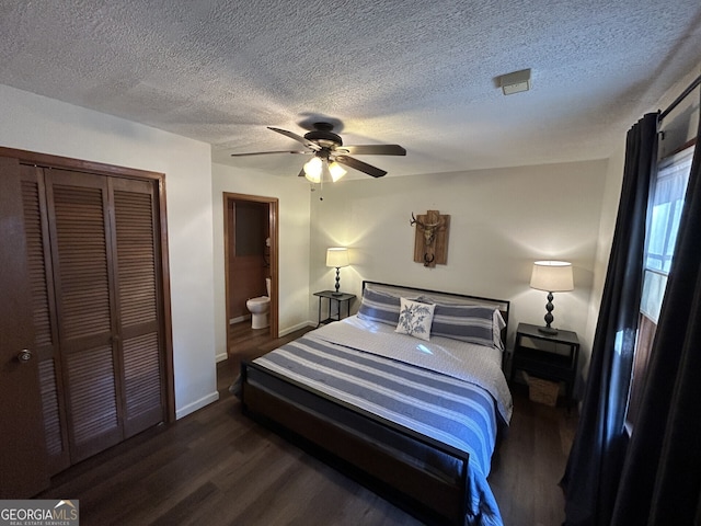 bedroom with ensuite bathroom, a textured ceiling, dark hardwood / wood-style flooring, a closet, and ceiling fan