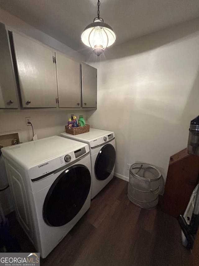 laundry room with cabinets, dark hardwood / wood-style floors, and washer and clothes dryer