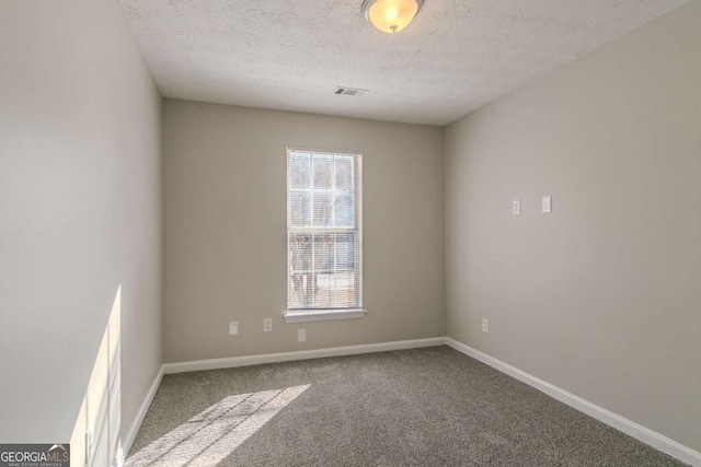 carpeted spare room with a textured ceiling