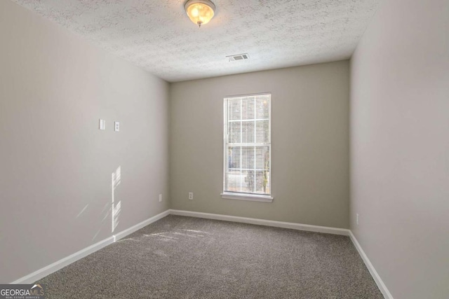 empty room featuring carpet and a textured ceiling