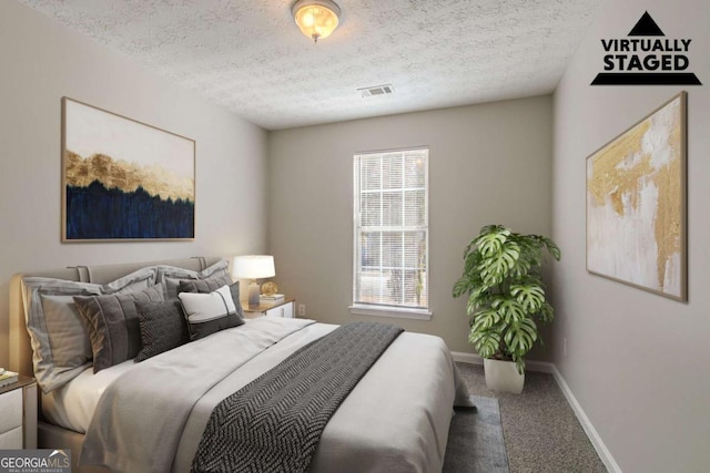 carpeted bedroom featuring a textured ceiling