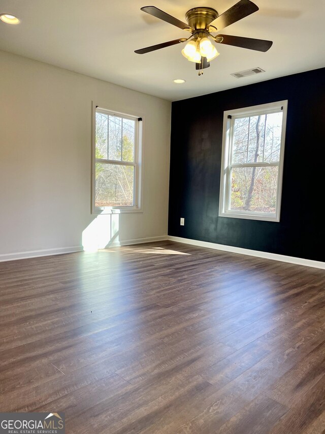 spare room featuring dark hardwood / wood-style flooring and ceiling fan