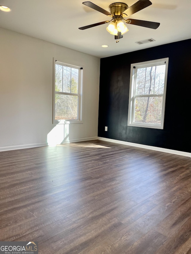 unfurnished room with ceiling fan and dark hardwood / wood-style flooring