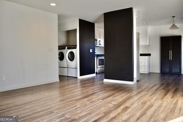 washroom featuring washing machine and dryer and light wood-type flooring