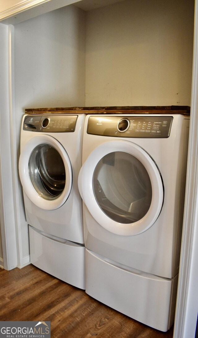 washroom featuring dark hardwood / wood-style flooring and washing machine and dryer