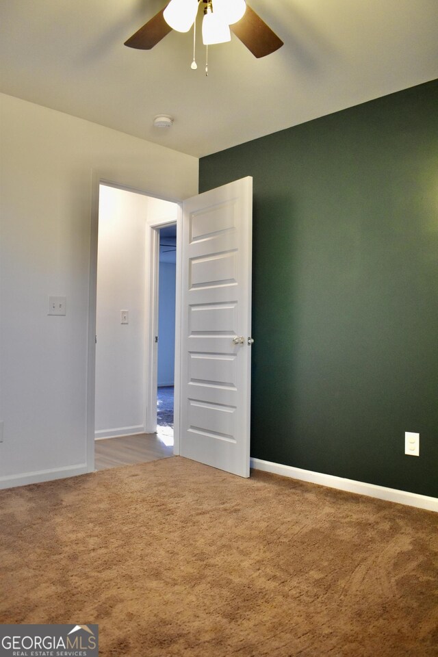 unfurnished room with carpet and ceiling fan