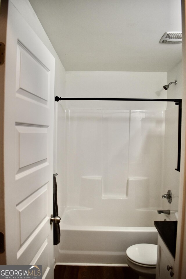 full bathroom featuring vanity, hardwood / wood-style floors, bathing tub / shower combination, and toilet