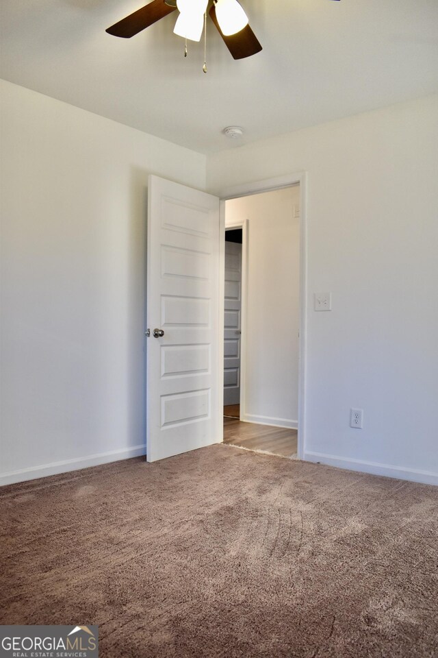 carpeted spare room featuring ceiling fan