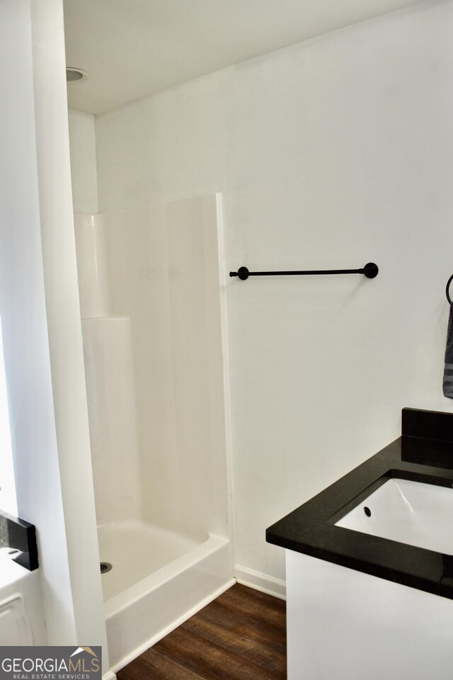 bathroom featuring vanity, hardwood / wood-style flooring, and walk in shower