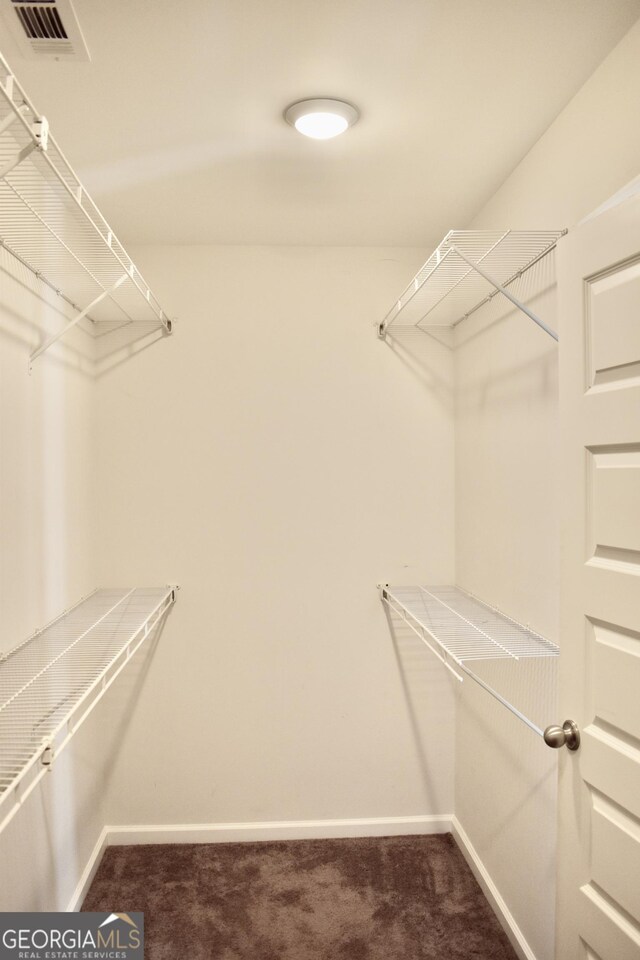 spacious closet featuring dark carpet