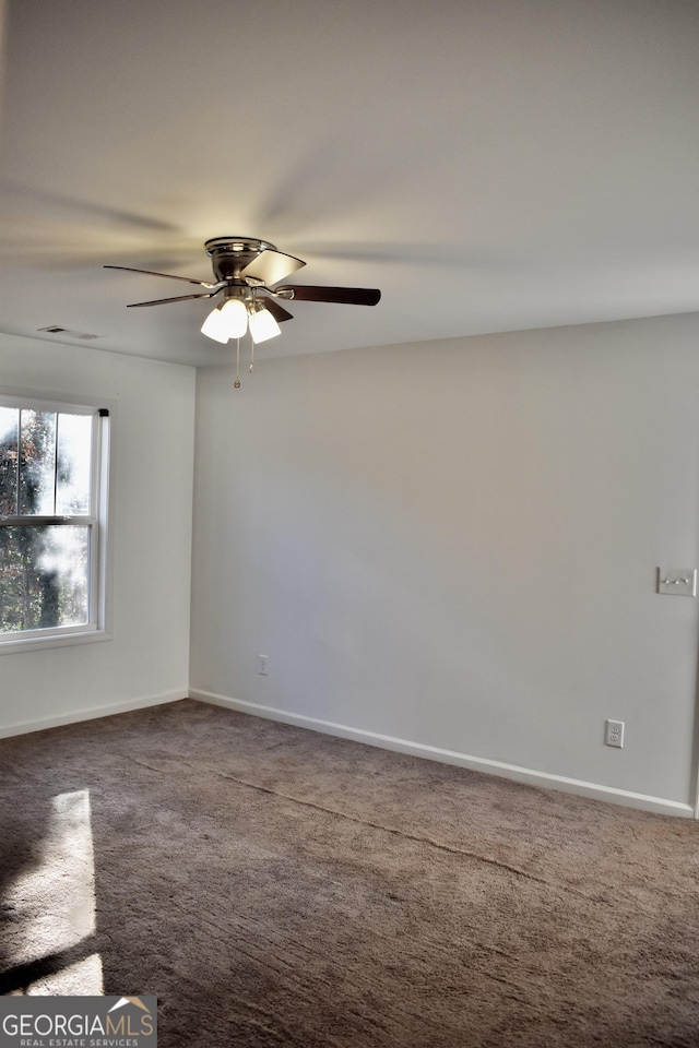 carpeted spare room with ceiling fan