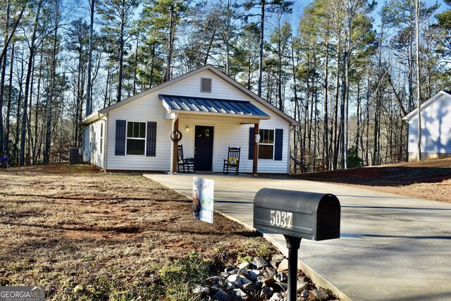 view of front of property featuring cooling unit and covered porch