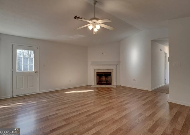 unfurnished living room with vaulted ceiling, ceiling fan, a fireplace, and light hardwood / wood-style floors