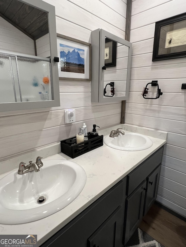 bathroom featuring vanity, an enclosed shower, and wood walls