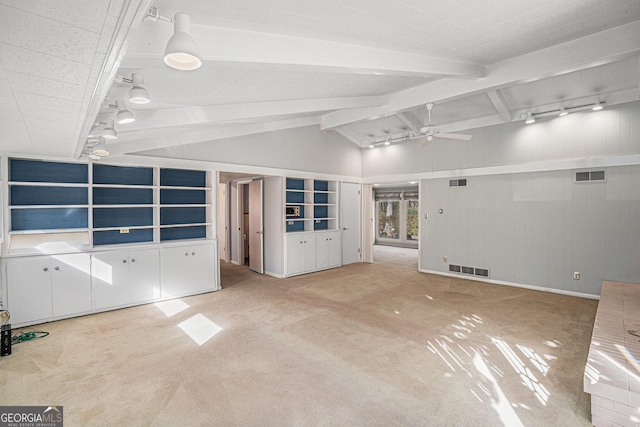 unfurnished living room with carpet floors, lofted ceiling with beams, ceiling fan, and track lighting