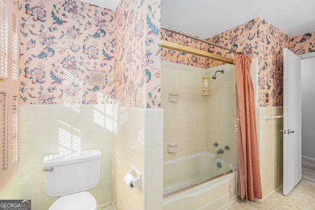 bathroom featuring toilet, shower / bathtub combination with curtain, and tile walls