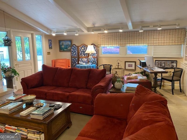 living room with beamed ceiling, rail lighting, and light carpet