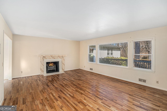 unfurnished living room with wood-type flooring and a fireplace