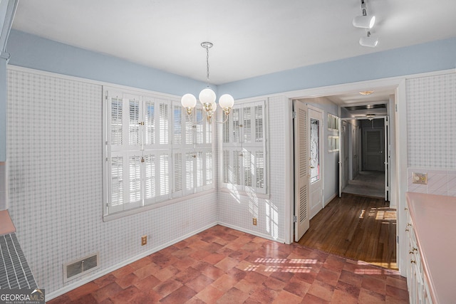 unfurnished dining area featuring a chandelier