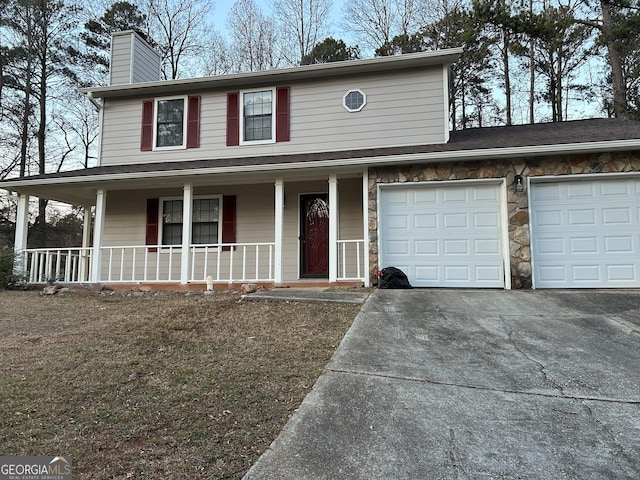 view of front of home featuring a garage, a front yard, and covered porch