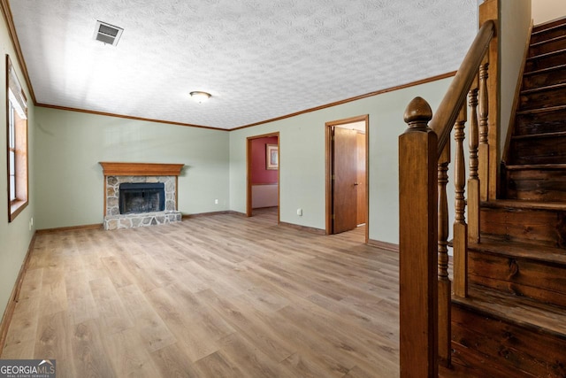 unfurnished living room featuring visible vents, a fireplace, stairway, and wood finished floors