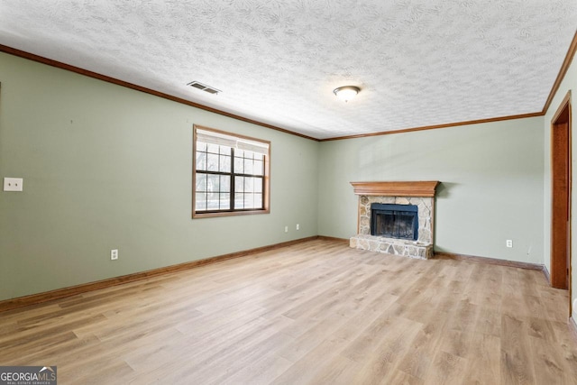 unfurnished living room with baseboards, visible vents, crown molding, light wood-type flooring, and a fireplace