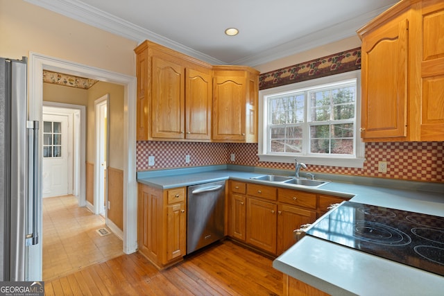 kitchen featuring crown molding, stainless steel appliances, sink, and light hardwood / wood-style flooring