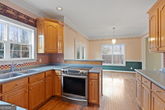 kitchen featuring electric stove, sink, pendant lighting, and ornamental molding