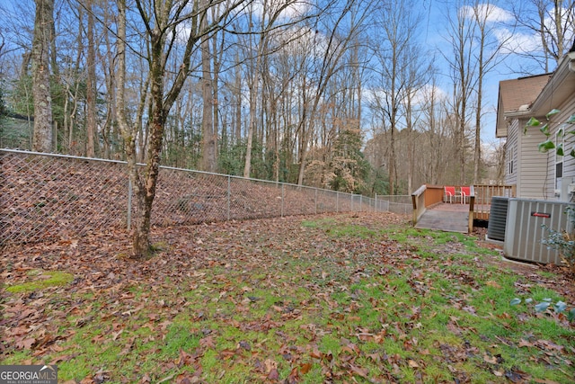 view of yard featuring cooling unit and a deck