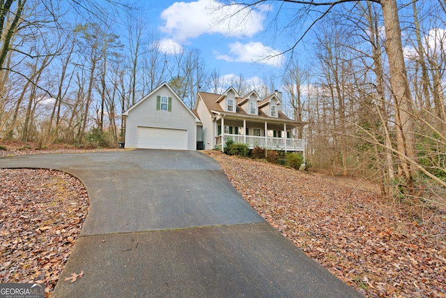 cape cod house with a garage and covered porch