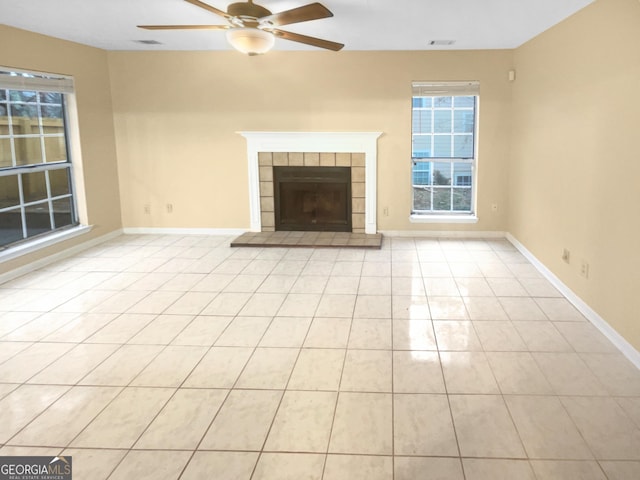 unfurnished living room featuring light tile patterned flooring, ceiling fan, and a tiled fireplace