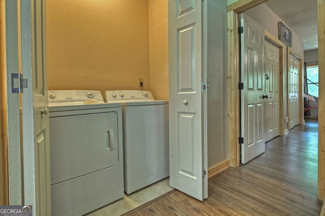 laundry area with wood-type flooring and separate washer and dryer