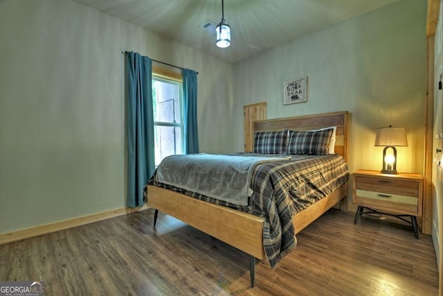 bedroom with dark hardwood / wood-style floors