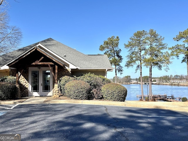 view of home's exterior featuring a water view and french doors