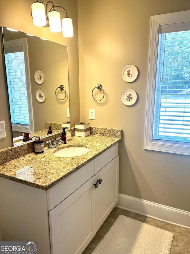 bathroom featuring vanity, a chandelier, tile patterned flooring, and a wealth of natural light