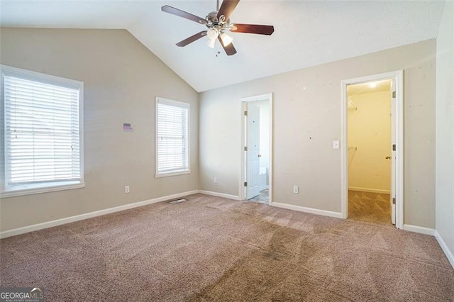 spare room featuring ceiling fan, vaulted ceiling, and carpet