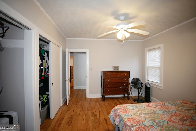 bedroom with crown molding, ceiling fan, a closet, and light wood-type flooring