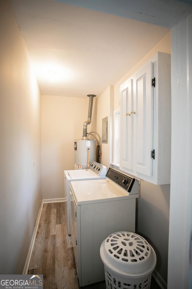 laundry room featuring hardwood / wood-style floors, water heater, separate washer and dryer, cabinets, and electric panel