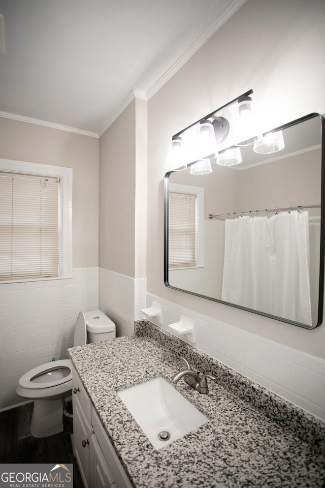 bathroom with vanity, ornamental molding, tile walls, and toilet