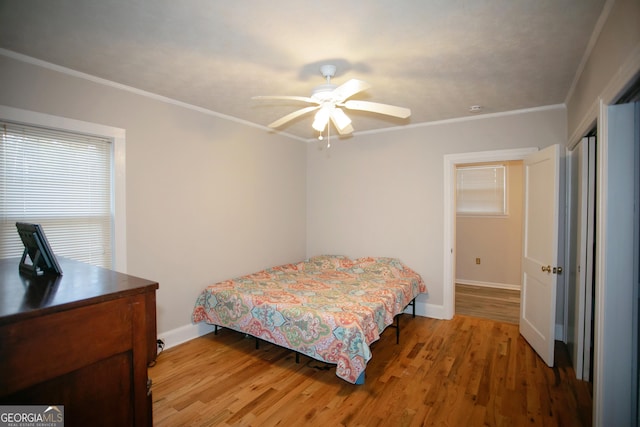 bedroom with ceiling fan, ornamental molding, and hardwood / wood-style floors