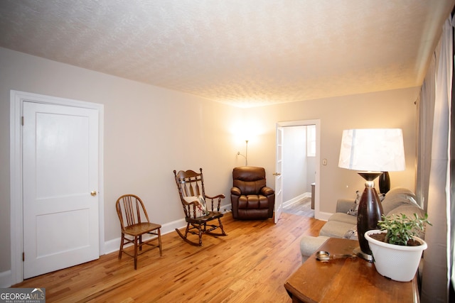 living area with a textured ceiling and light wood-type flooring