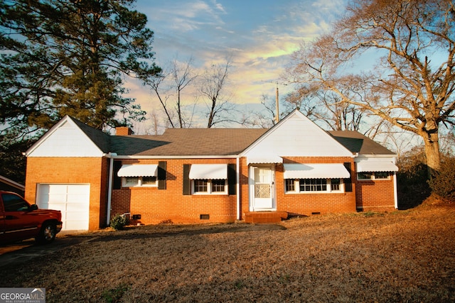 ranch-style house with a yard and a garage